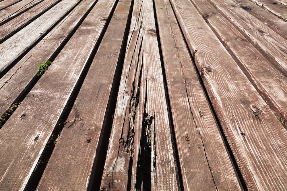 Old damaged brown wooden deck background texture with perspective effect