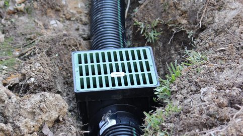 Drainage ditch. Laying a drainage pipe using rain drainage sewage pipe and box. Earthwork.