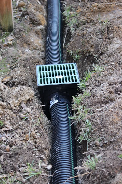 Drainage ditch. Laying a drainage pipe using rain drainage sewage pipe and box. Earthwork.