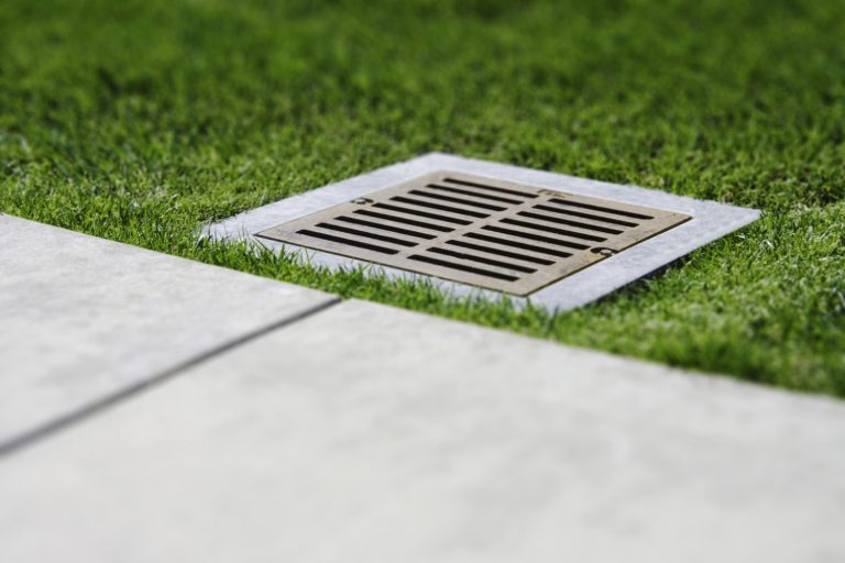 A tilt shift image of a water drain grate close-up.