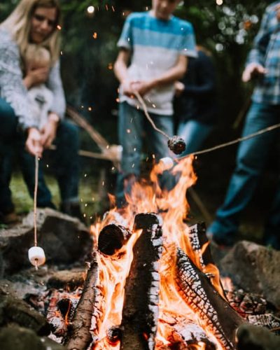 family toasting marshmallows over a fire
